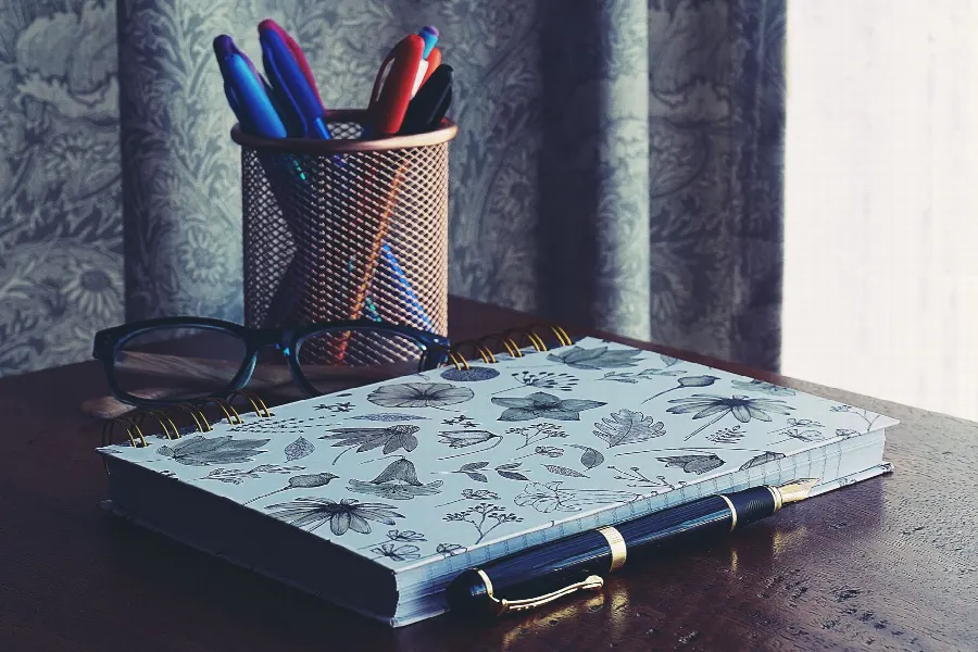 Carnet et stylo posés sur un bureau